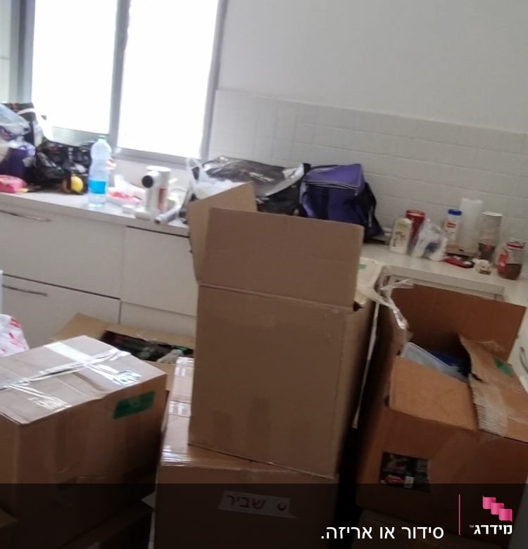 קופסאות קרטון על הרצפה במטבח מבולגן